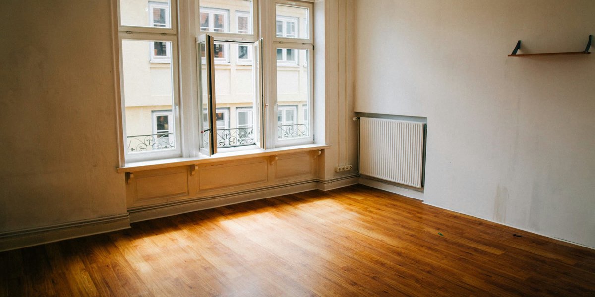 Leeres Zimmer mit großen Fenstern und Holzboden